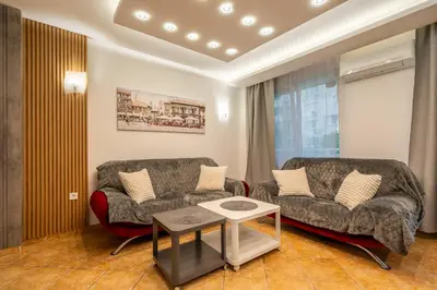 a living room with two couches and a table at Marble place in Sofia