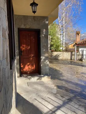 a door to a house with a stone wall at Къща за гости Рупчос 1 in Smolyan