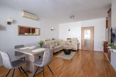 a living room with a couch and a table and chairs at Spacious 1 bedroom apartment in a lively center in Sofia
