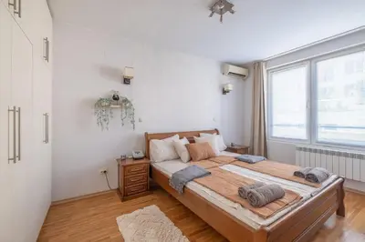 a bedroom with a large bed and a large window at Spacious 1 bedroom apartment in a lively center in Sofia