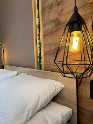 a bedroom with a bed and a hanging lamp at VeliApartmets in Velingrad