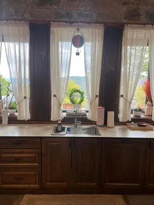 a kitchen with a sink and two windows at Къща в Родопа планина in Leshten