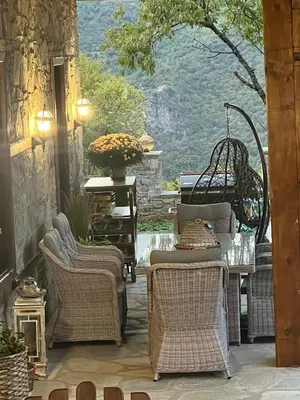 a patio with a table and chairs and a window at Къща в Родопа планина in Leshten