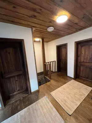 an empty room with wooden doors and wooden floors at Къща в Родопа планина in Leshten