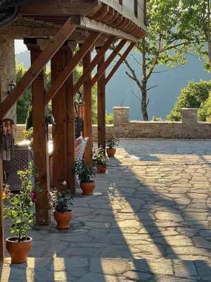 a wooden pergola with potted plants on a patio at Къща в Родопа планина in Leshten