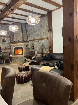 a living room with leather furniture and a fireplace at Къща в Родопа планина in Leshten