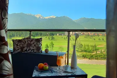 a balcony with a table with a view of the mountains at Ski Retreat Spa Pool and Mountain Views in Bansko