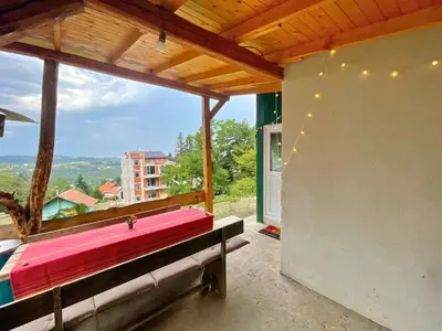 a room with a large window with a pink bed at Kъщичка в полите на планина Витоша с коне и животни in Sofia