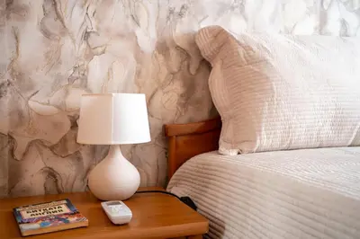 a lamp on a table next to a bed at Center and Old Town Apartment in Plovdiv