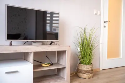 a television on a wooden tv stand in a living room at Center and Old Town Apartment in Plovdiv