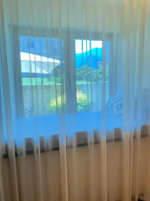 a window with blue curtains in a room at Downtown Bansko Luxury Resort in Bansko