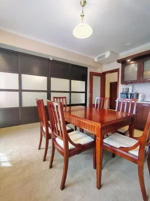 a dining room with a wooden table and chairs at 3 Rooms Apartment next to the Ski lift in Bansko