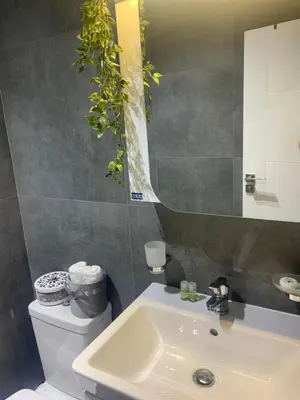 a bathroom with a white sink and a mirror at The Modern Nest Apartment with FREE Underground Parking in Plovdiv