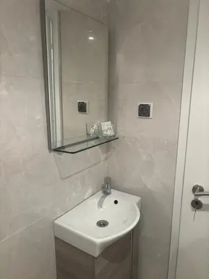 a white bathroom with a sink and a mirror at Kolev Apartment in Sofia