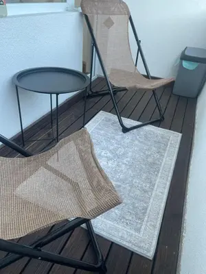 two chairs and a table and a table and a rug at Апартамент Кashmir in Smolyan