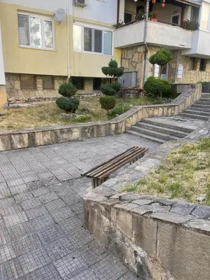 a wooden bench sitting in front of a building at Апартамент Кashmir in Smolyan
