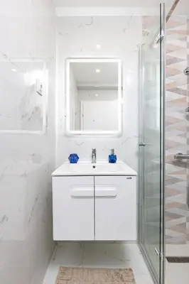 a white bathroom with a sink and a mirror at Casa Moderna - Stylish 1BD in South Plovdiv by Flat Manager in Plovdiv