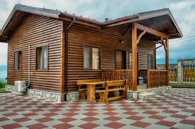 a wooden cabin with a wooden bench in front of it at Yoneda Houses in Sapareva Banya