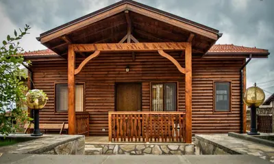 a log cabin with a porch and a wooden door at Yoneda Houses in Sapareva Banya