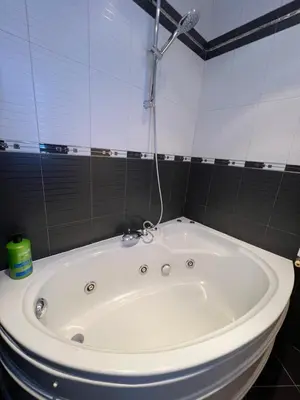 a white bath tub in a tiled bathroom at Cozy 1BDR with Jacuzzi and WiFi near Vitosha BLVD in Sofia