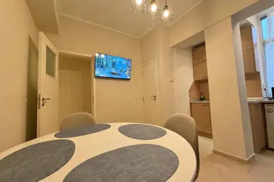 a dining room with a table and chairs and a television at Cozy 1BDR with Jacuzzi and WiFi near Vitosha BLVD in Sofia