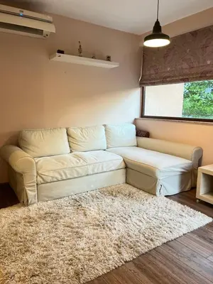 a living room with a white couch and a rug at Guest House Amaya Happy in Plovdiv