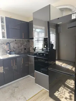 a kitchen with black cabinets and a sink at Самостоятелен Apartment Emili in Sapareva Banya