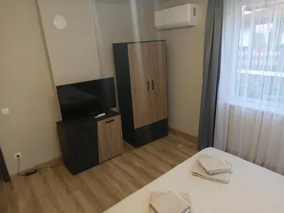 a room with a bed and a tv and a bed sidx sidx sidx at Самостоятелен Apartment Emili in Sapareva Banya