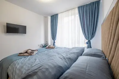 a bedroom with a large bed with a window at Elegant Deluxe 2 Bedroom apartment in Sofia