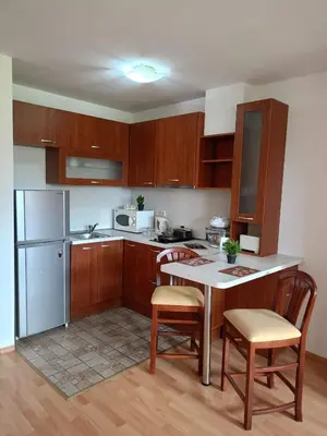 a kitchen with wooden cabinets and a table and chairs at Mountain Paradise 1 - 2 Bedroom - Large apartment in Bansko