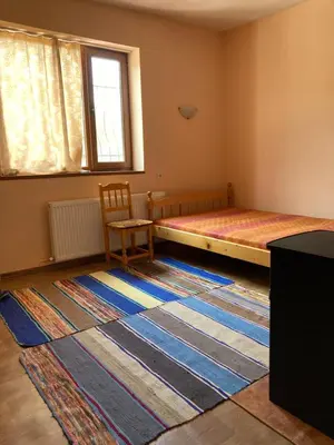 a bedroom with a bed and a chair and a rug at Диковата къща in Lesidren