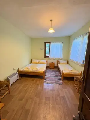 a large room with two beds in it at Диковата къща in Lesidren