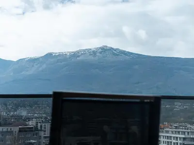 a computer monitor in front of a mountain at APEX Apartments Sofia - MountainView in Sofia