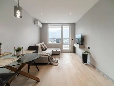 a living room with a couch and a table at APEX Apartments Sofia - MountainView in Sofia
