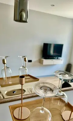 a kitchen with two wine glasses on a counter at APEX Apartments Sofia - MountainView in Sofia