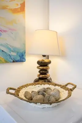a lamp on a table with a basket with rocks at Mountain view apartment in Aspen Golf Resort with SPA in Bansko