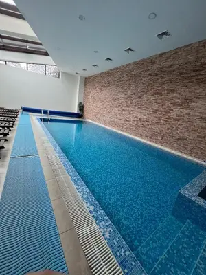 a large swimming pool in a building with a brick wall at Mountain view apartment in Aspen Golf Resort with SPA in Bansko
