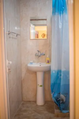 a bathroom with a sink and a shower curtain at Guest House JoJi in Sapareva Banya