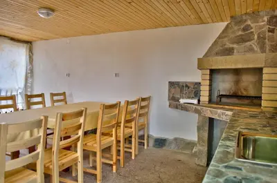a dining room with a table and a fireplace at Guest House JoJi in Sapareva Banya
