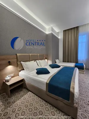 a hotel room with two beds and a sign on the wall at Central Hotel Sofia in Sofia