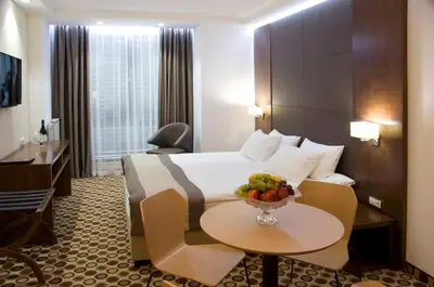 a hotel room with a bed and a bowl of fruit on a table at Central Hotel Sofia in Sofia