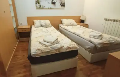 two beds in a small room with towels on them at Lara's cosy apartment 200 m from lift in Bansko