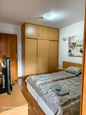 a bedroom with two beds and a tv in it at Lara's cosy apartment 200 m from lift in Bansko