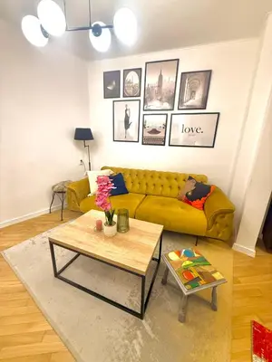 a living room with a yellow couch and a table at Luxury apartment in the heart of Sofia in Sofia