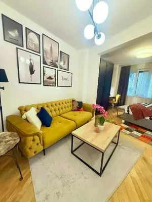 a living room with a yellow couch and a table at Luxury apartment in the heart of Sofia in Sofia