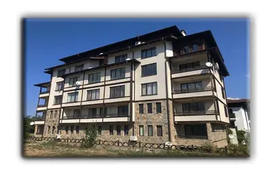 a tall white building with a black roof at Studio Resonance Bansko in Bansko