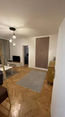 an empty living room with a table and a couch at Кокетно Кътче in Sofia