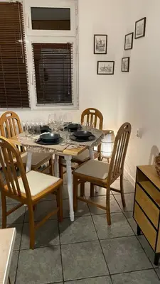a dining table and chairs with wine glasses on it at Кокетно Кътче in Sofia
