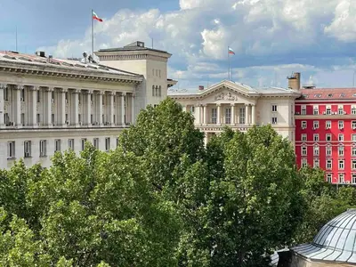 a white building with two flags on top of it at Superbe last floor next Presidency in Sofia