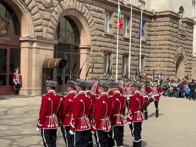 a group of men in red uniforms walking down a street at Superbe last floor next Presidency in Sofia